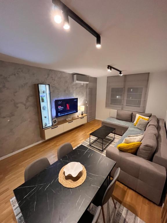 a living room with a couch and a table at Apartman A&V in Vranješ