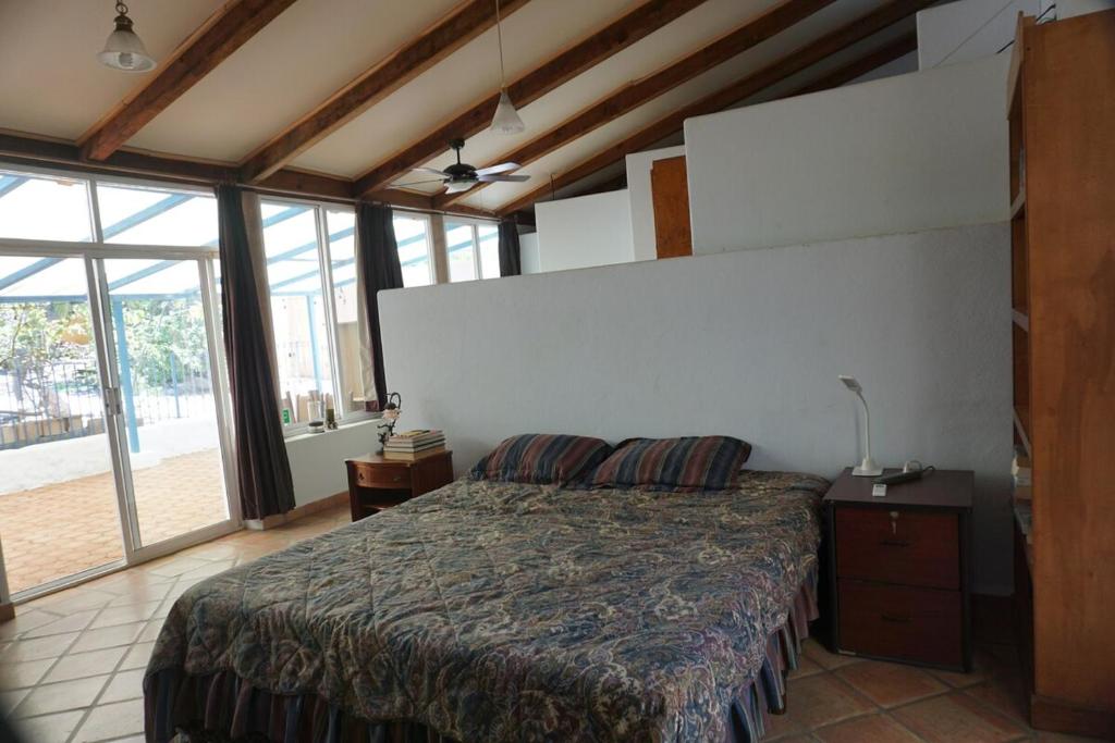 a bedroom with a bed in a room with windows at Large studio with private patio in Casa Cornucopia in San José del Cabo