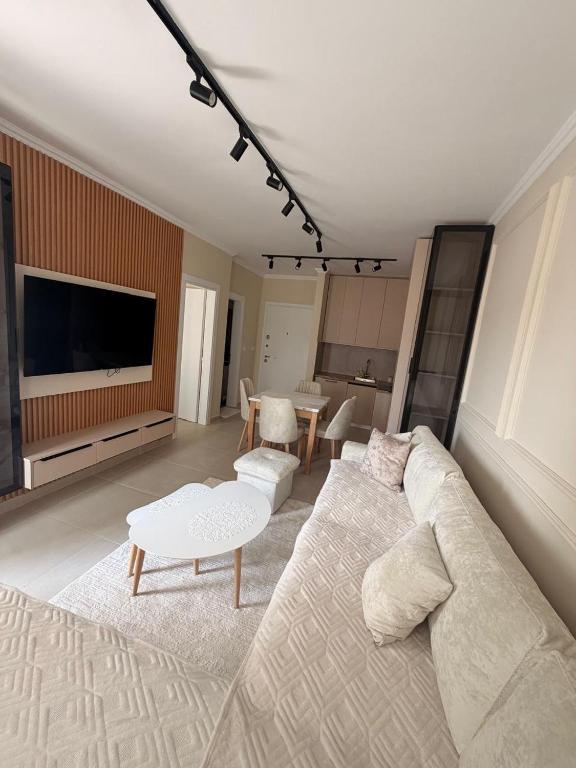 a living room with a white couch and a table at Golem Escape in Kavajë