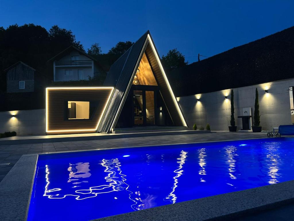 a house with a swimming pool at night at A-Frame Villa - Kovačević Hills in Velika Kladuša