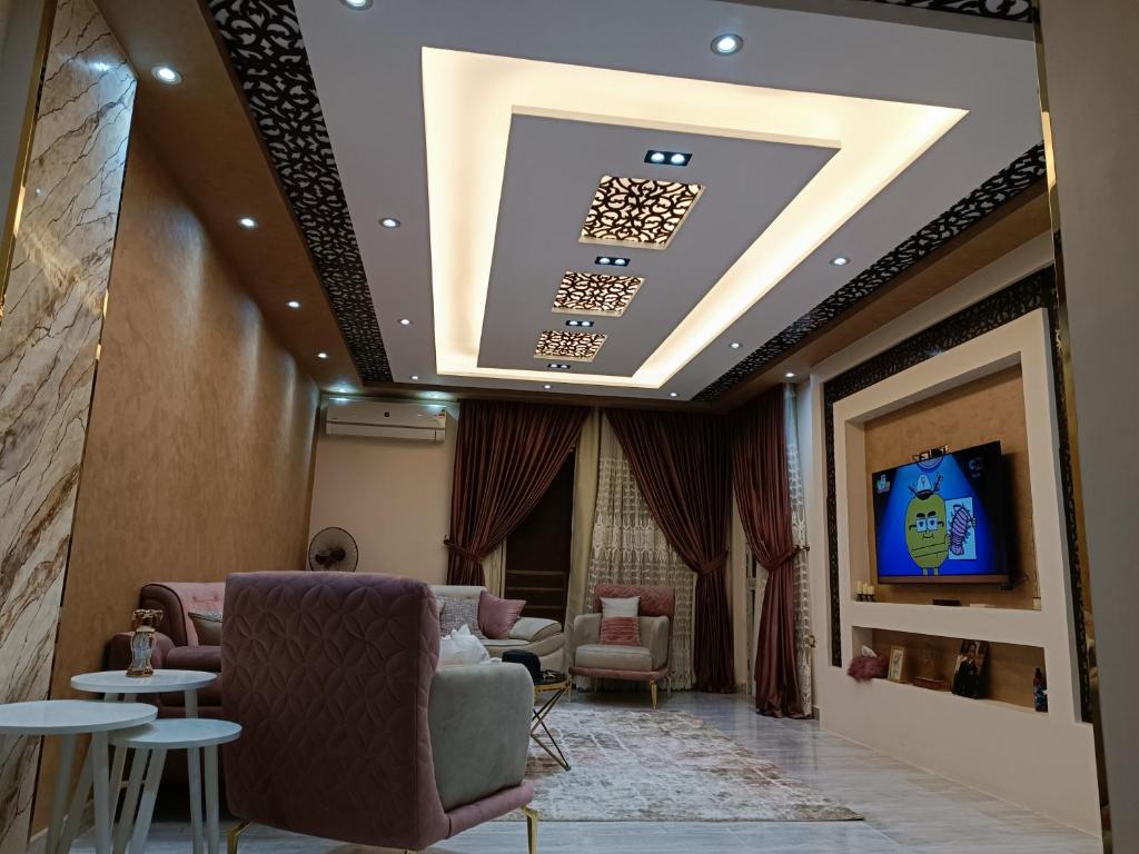 a living room with a couch and a tv on a ceiling at عمارة 14 in Madīnat ash Shurūq