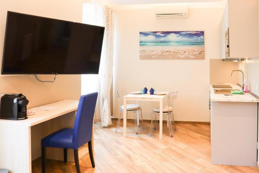 a room with a desk and a table with chairs at Sanremo Apartments - A Due Passi in Sanremo