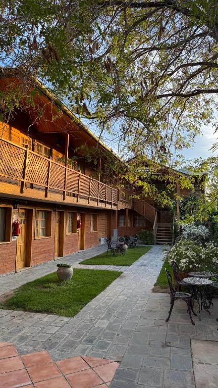 ein Innenhof eines Gebäudes mit einem Tisch und Bänken in der Unterkunft Don Costa in Chos Malal