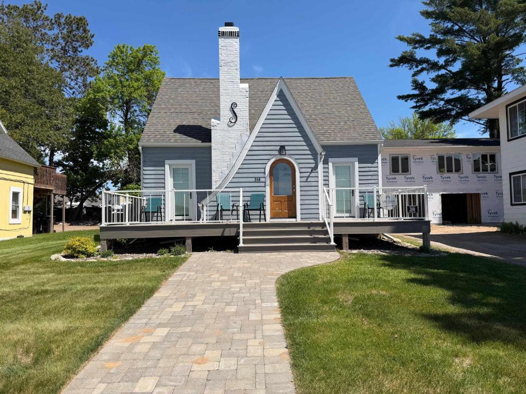 a house with a large porch and a tower at The Catalog Cottage in Minocqua
