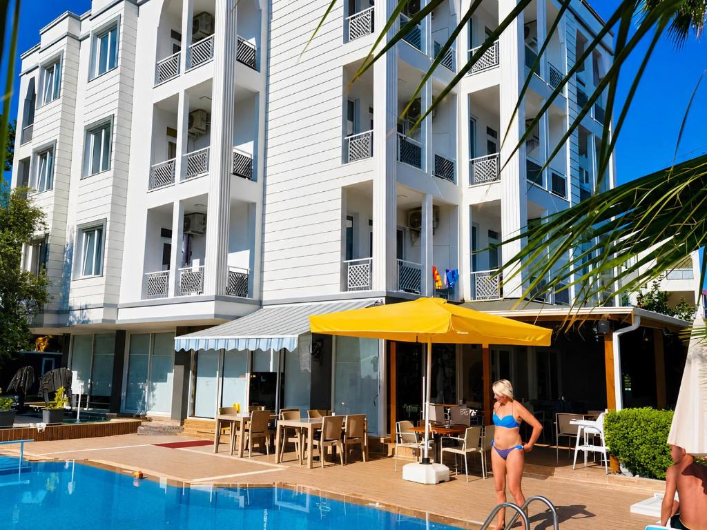 a woman standing in front of a hotel with a pool at Esperanza Hotel in Antalya