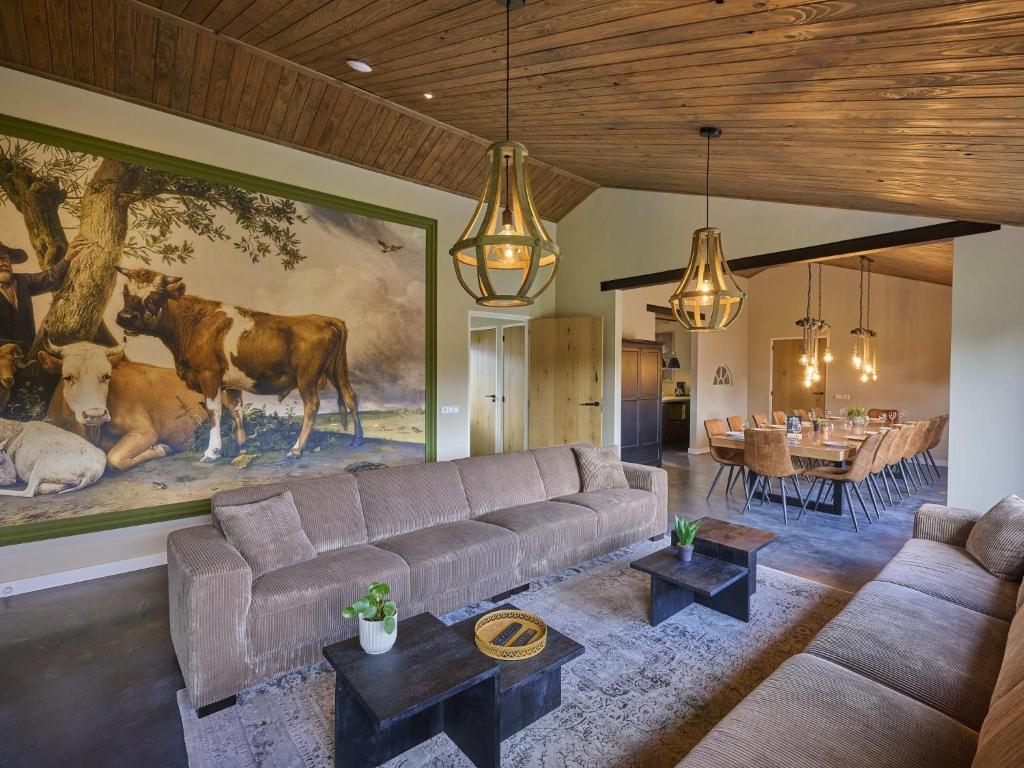a living room with a couch and a painting of cows at Sientjeshof 2 in Diessen