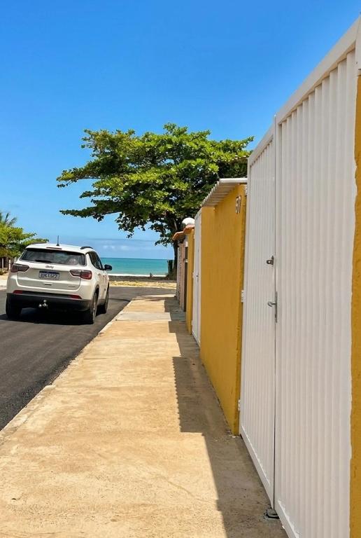 a car parked on a sidewalk next to a building at Casa Bali Beira Mar - Sesc Bertioga in Bertioga