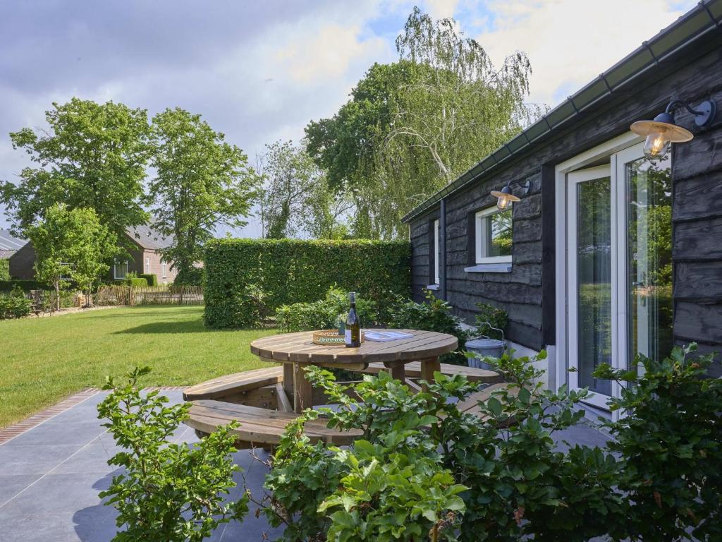 a patio with a wooden table in a yard at Sientjeshof 1 in Diessen