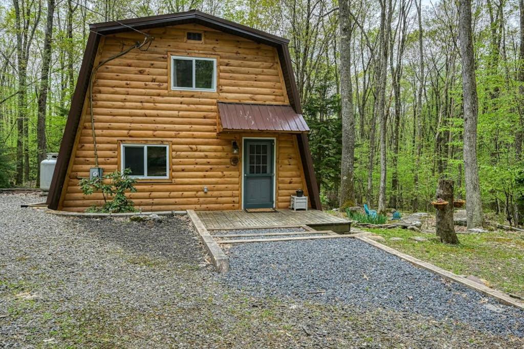 a log cabin in the woods with a front door at Woodsy Way Cabin in Oakland