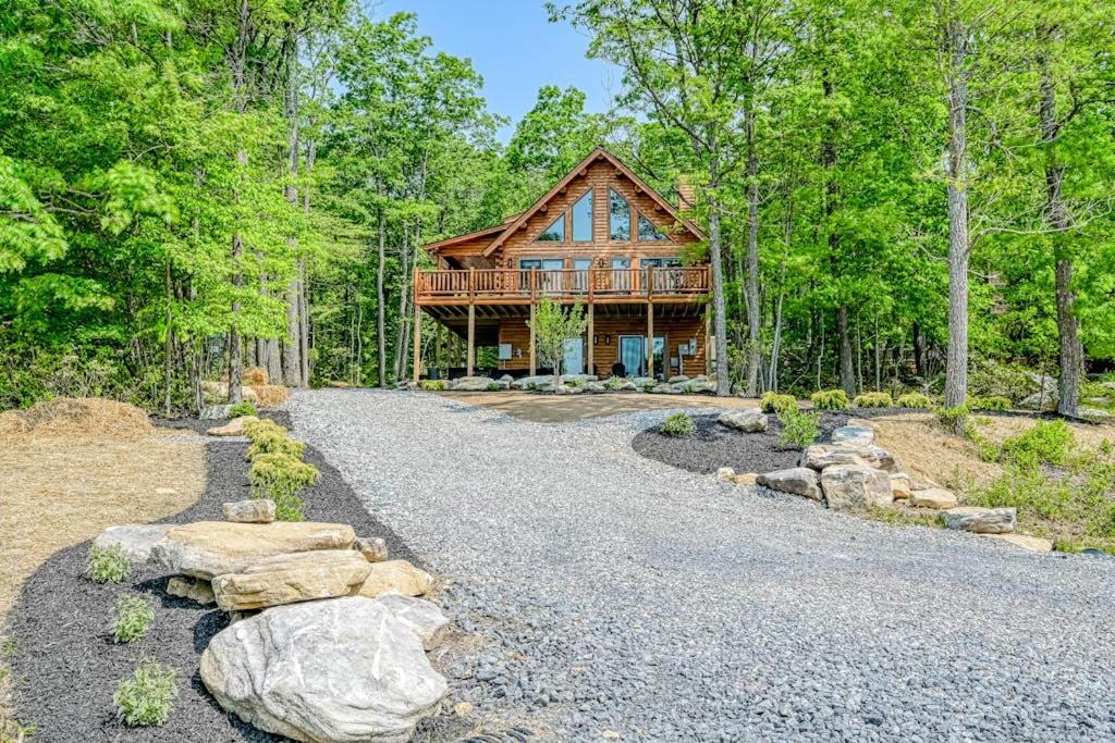 a log cabin in the woods with a gravel driveway at Deep Creek Mountain Retreat in McHenry