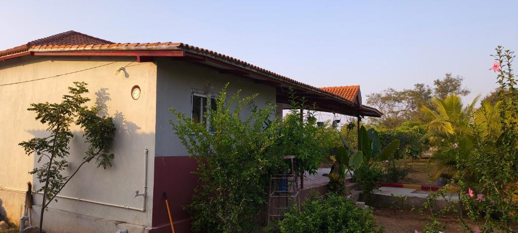 a small white house with a garden in front of it at Surya farms in Rajiv Gandhi International Airport
