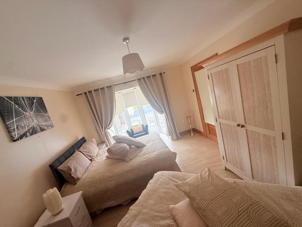 a bedroom with two beds and a large window at Dolly's Homestay in Galway