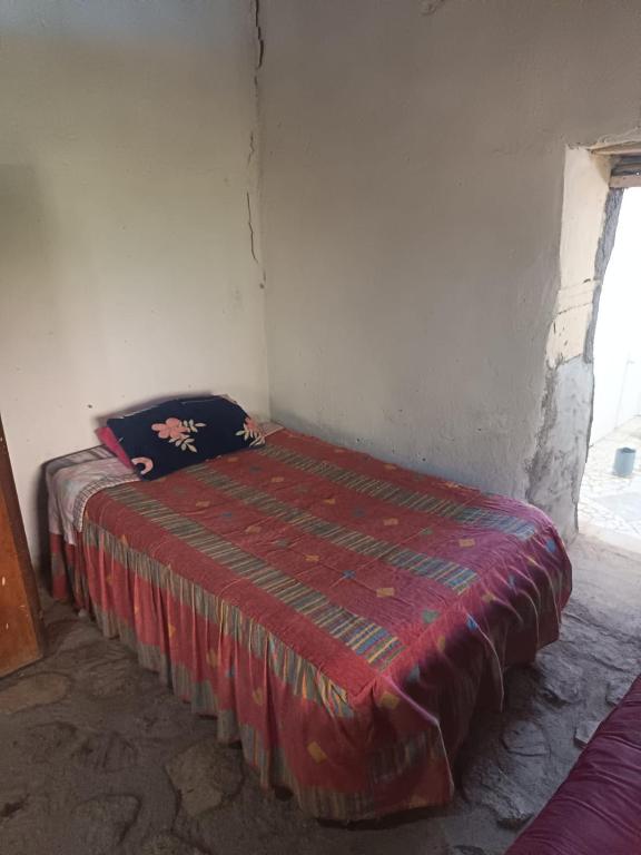 a bed in a corner of a room at Hostal Rústico Las Pircas in Alcoguaz