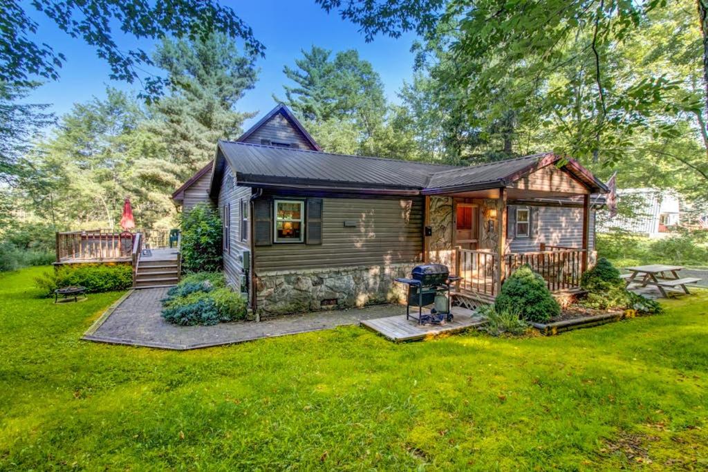 a tiny house with a deck and a yard at Life's A Bear in McHenry