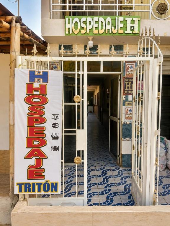 a hotel sign on the front of a building at Hospedaje Triton in Máncora