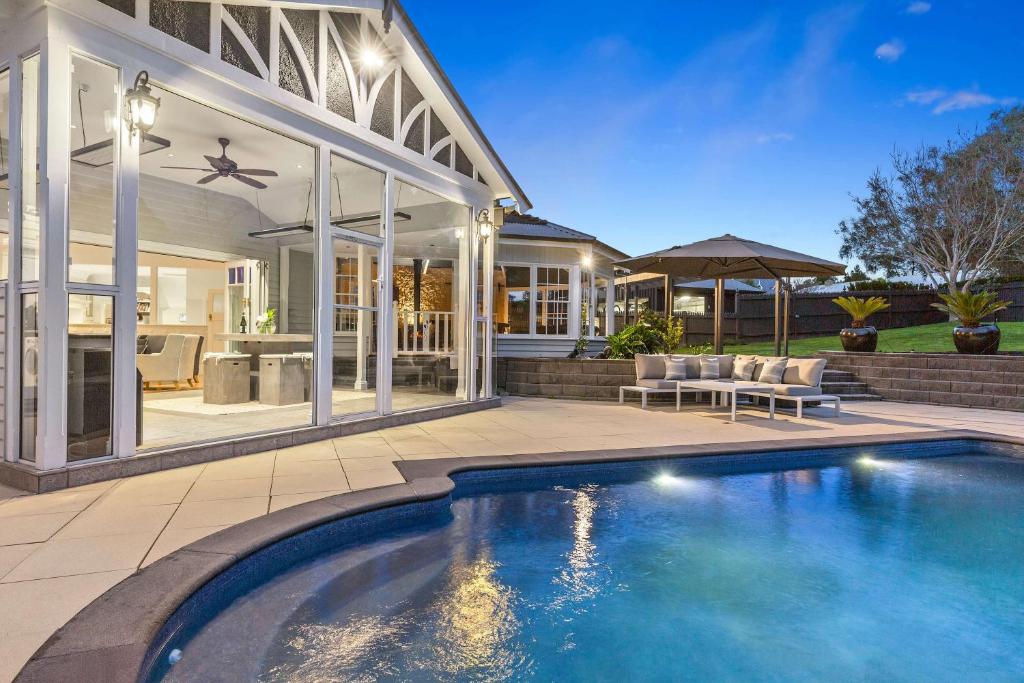 a swimming pool in front of a house at Kirinaran Manor Pool & Bar Room in Frankston South