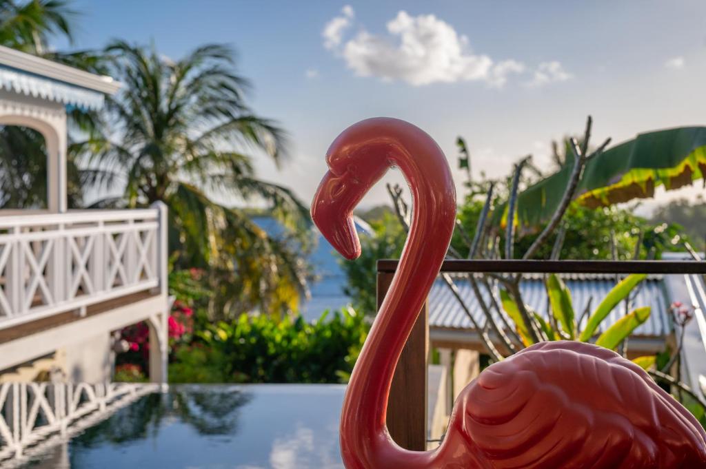 a red flamingo statue next to a swimming pool at Combava à Marie Galante in Grand-Bourg