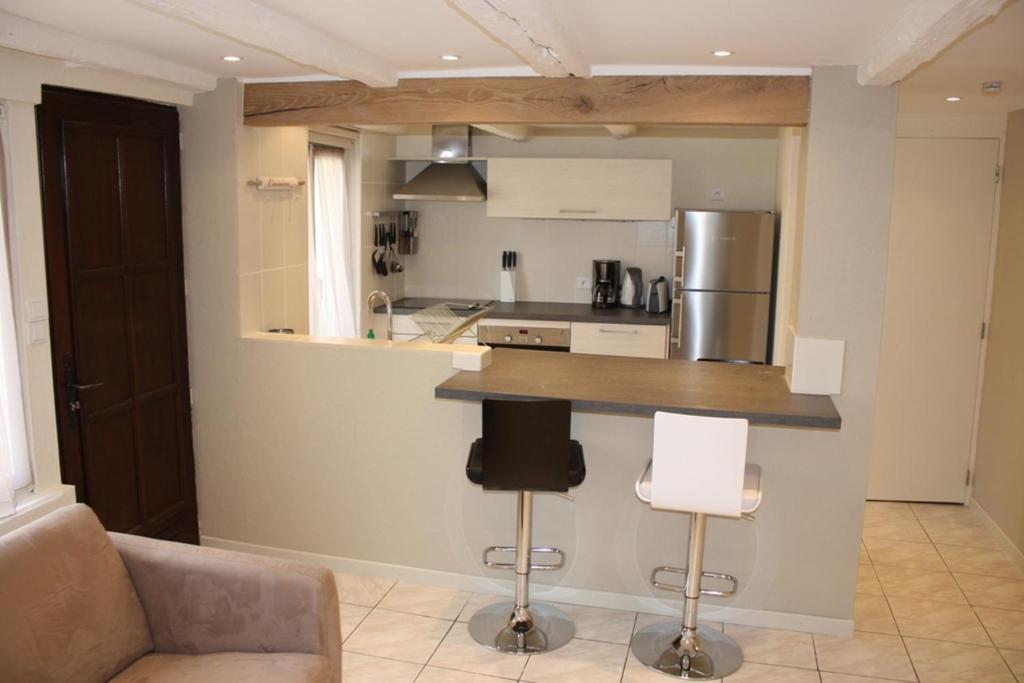 a kitchen with a counter and some chairs in a room at Gites des Dix Vins in Dangolsheim