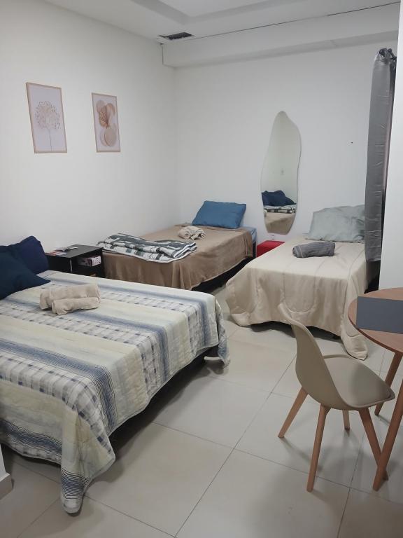 a room with three beds and a chair in it at COLOFT - Studio Térreo com Acessibilidade in Anápolis