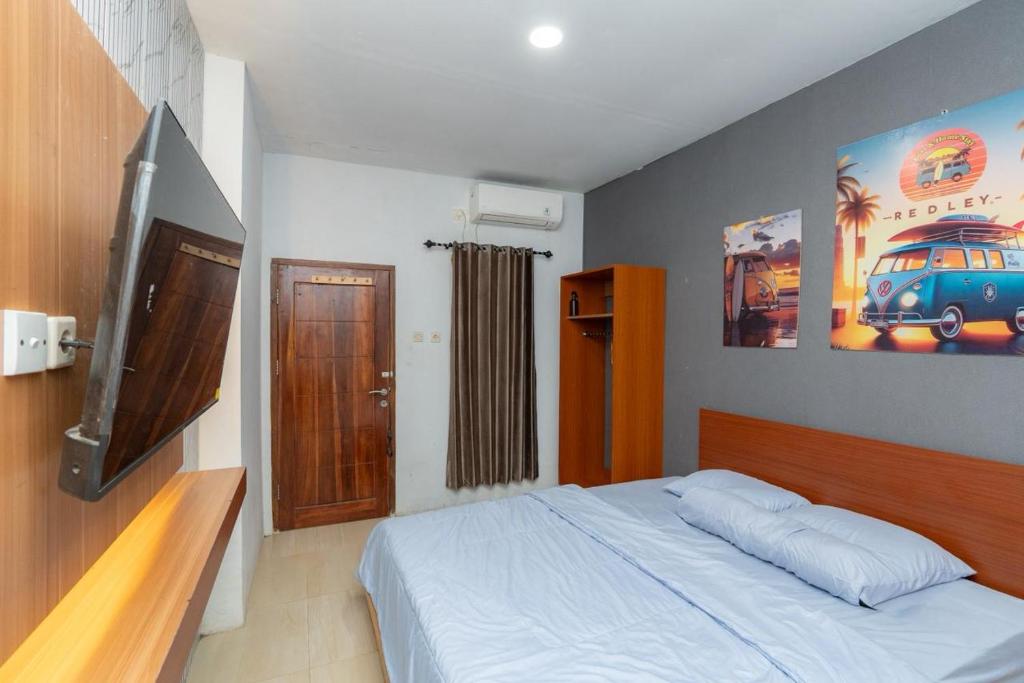 a bedroom with a bed and a flat screen tv at Heyho Homestay Maluk in Maluk