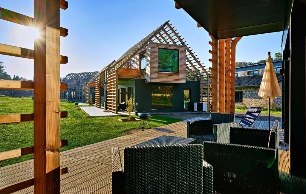 eine Holzterrasse mit Stühlen und ein Haus in der Unterkunft Haus 5 in Wendorf