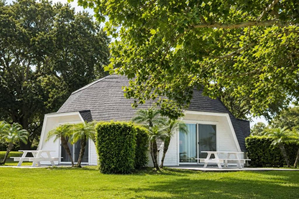 a house with a black roof and two white tables at STUDIO 02 - Lake Sumner in Clermont