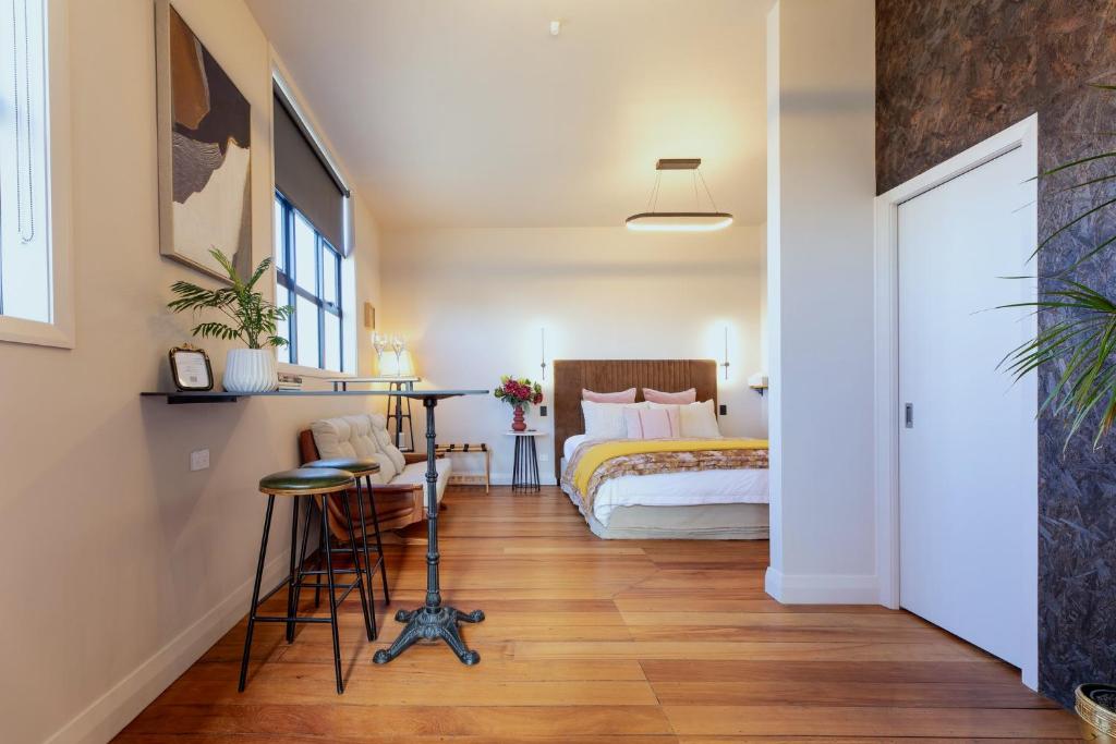 a bedroom with a bed and a table and chairs at The Verdict in Martinborough
