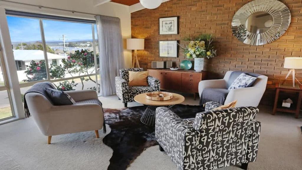 a living room with two chairs and a table at PiPis on Collins in Merimbula