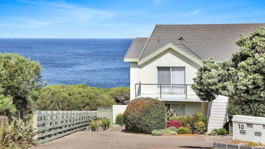 a white house with the ocean in the background at Quarterdeck 3 in Tura Beach