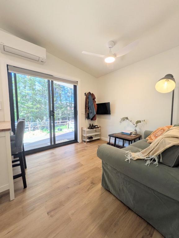 a living room with a couch and a sliding glass door at Elm's Deep Guest House in Berridale