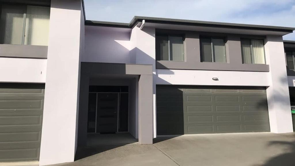 a house with a garage with a white arrow on it at Coastal Escape in Tura Beach