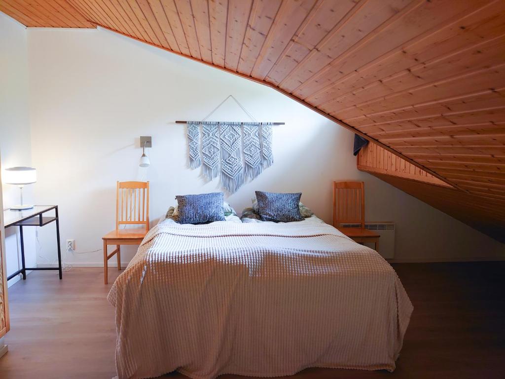 a bedroom with a large bed with a wooden ceiling at Holidayhome RintintinTahko in Tahkovuori