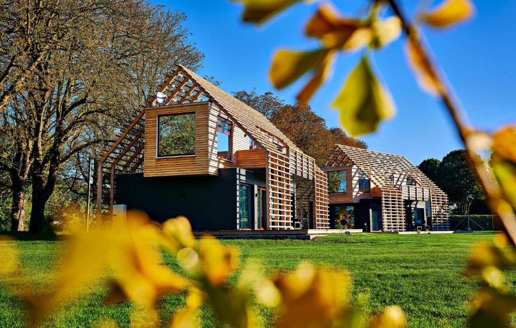 a house on a green field with trees in the foreground at Haus 8 in Wendorf