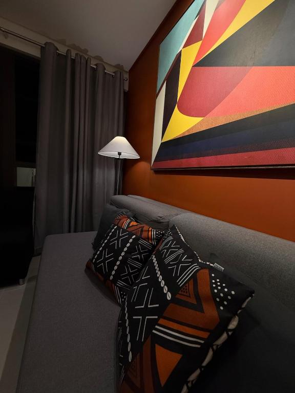 a bedroom with a bed with a painting on the wall at Flat completo e aconchegante em Caruaru in Caruaru