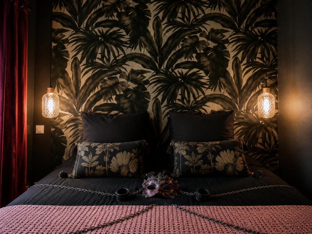 a bedroom with a bed with a floral wallpaper at ღ Love Room intime - Sauna - Hmm OH Oui ღ in Saint-Quentin
