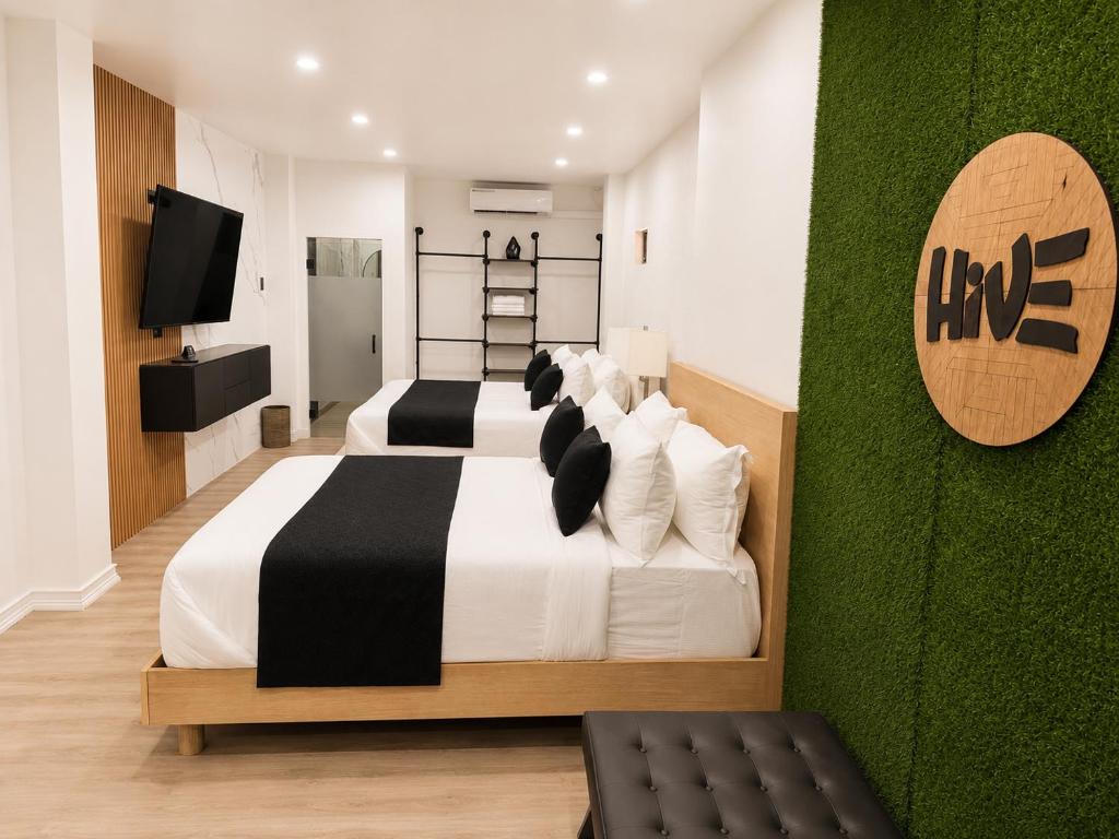 a bedroom with two beds and a television at The Hive Boutique Hotel Pool Suite 108 in Scarborough