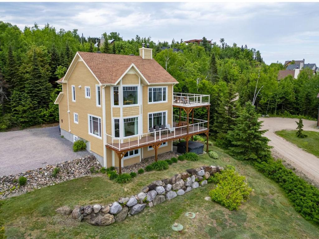 an aerial view of a large house with a deck at Panoramic View 2BR FP BBQ Terrace - Upper in Petite-Rivière-Saint-François