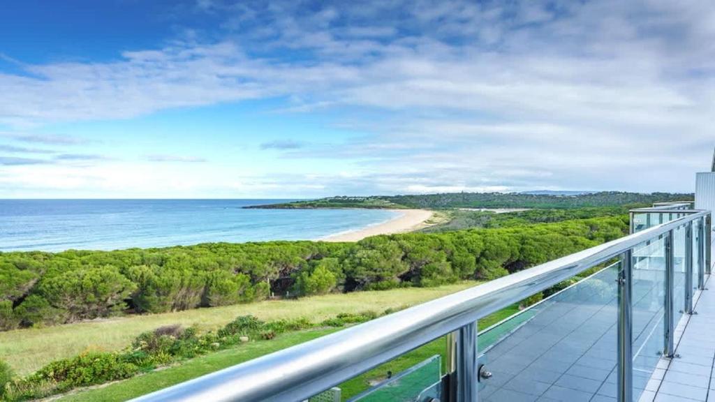 a balcony with a view of a beach and the ocean at Quarterdeck 6 in Tura Beach