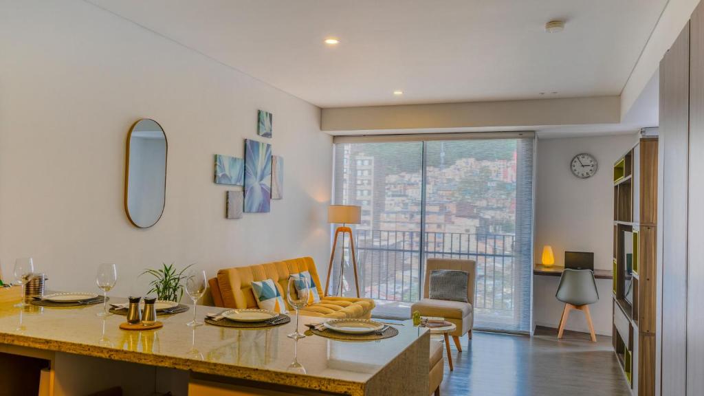 a kitchen and living room with a table and a living room at Espectacular Central Loft in Bogotá