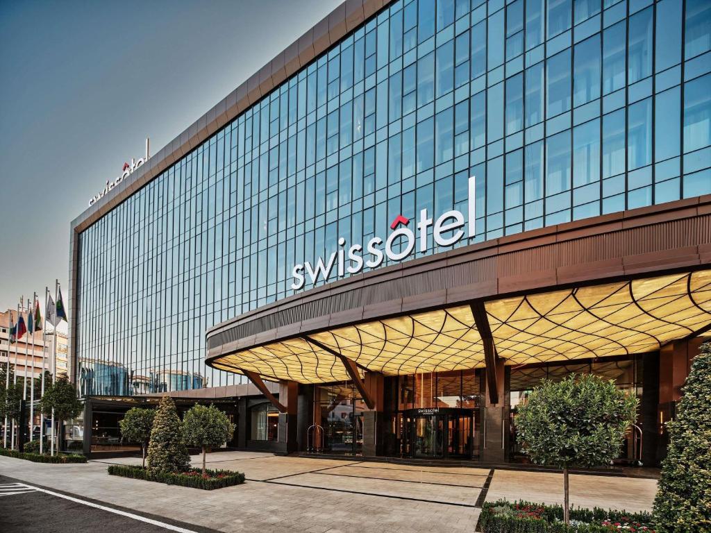 a building with a sign on the side of it at Swissotel Tashkent in Tashkent