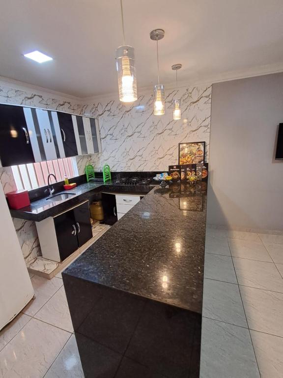 a kitchen with a black counter and a sink at Conexão Cariri in Juazeiro do Norte