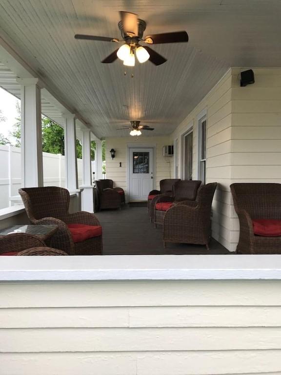 a porch with chairs and a ceiling fan on a house at 1 Bed 1 Bath Suite On Strip in Geneva