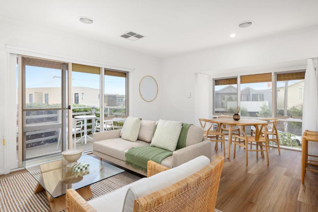 a living room with a couch and a table at Sunset Drift Edithvale Steps to Beach in Edithvale