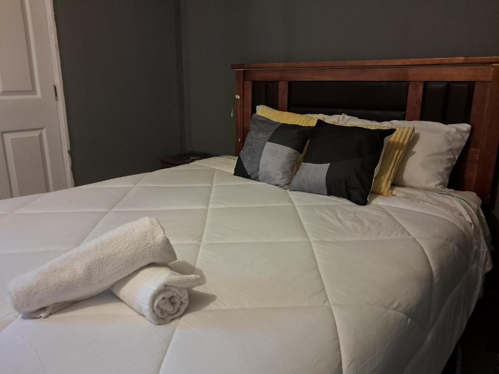 a white bed with a folded towel on it at El Laurel in Chillán