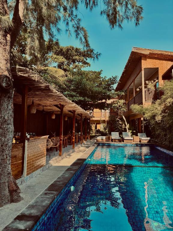 a swimming pool in front of a house at Home Dejavu in Gili Trawangan