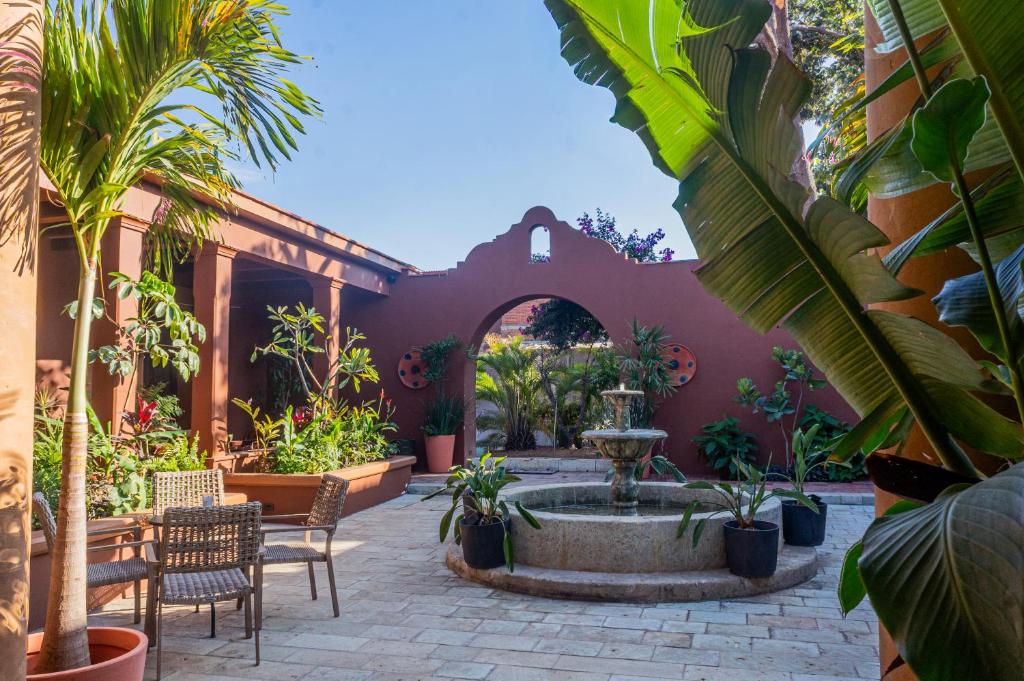 a courtyard with a fountain and chairs and plants at Red Tree Oaxaca in Oaxaca City