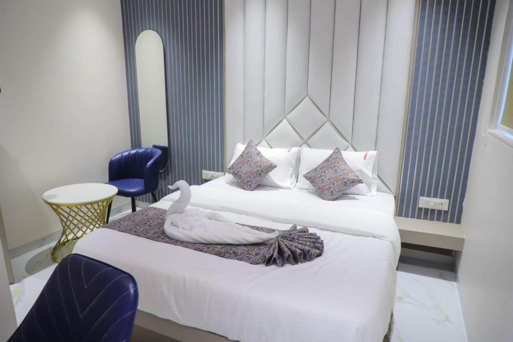 a hotel room with a bed with a swan on it at Ashray Guest House in Kalyan