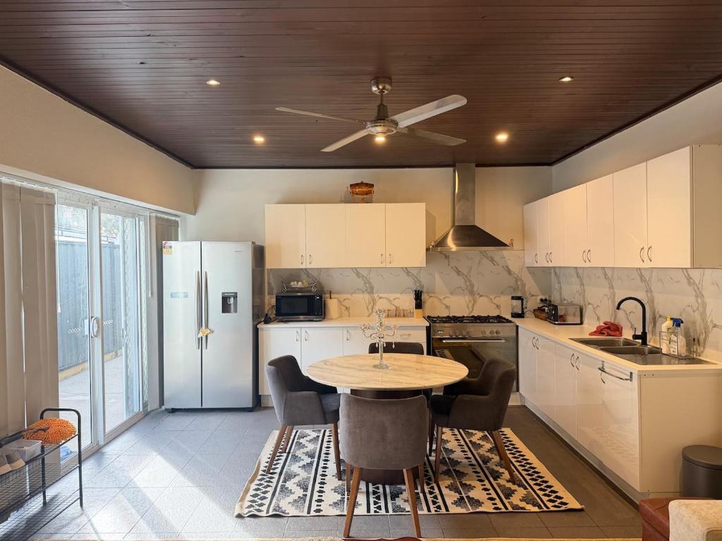 a kitchen with a table and a refrigerator at The Hideaway in Sydenham
