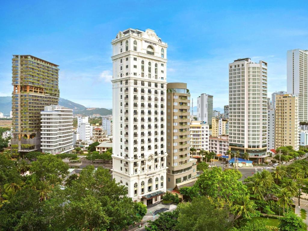 a tall white building in the middle of a city at Mercure Nha Trang Beach in Nha Trang