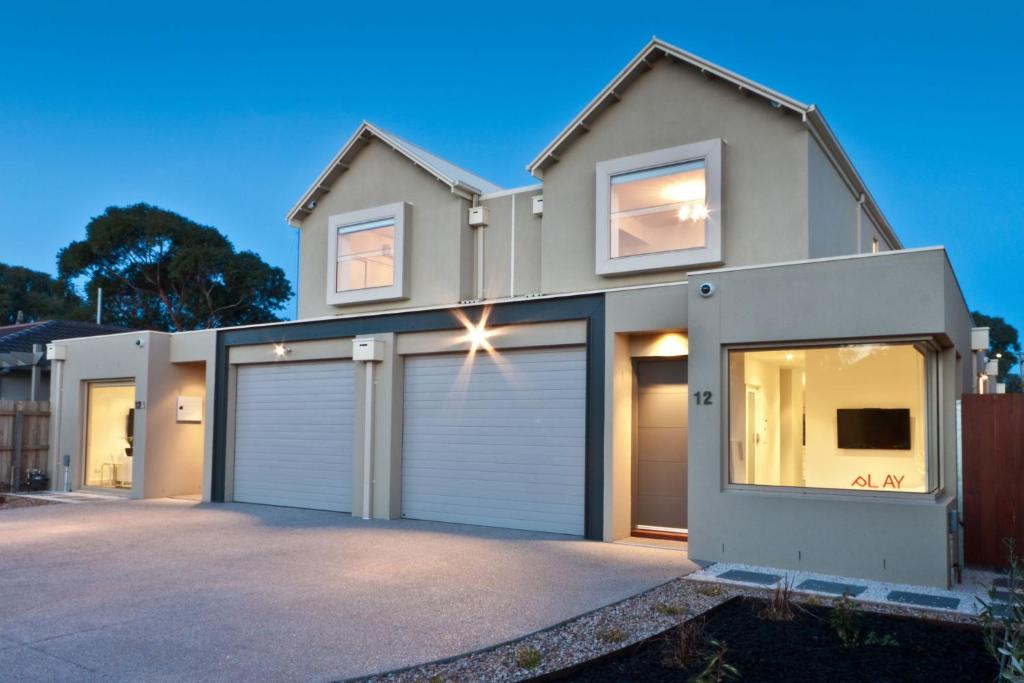 a house with two garage doors in a driveway at Amaroo by the beach in Queenscliff
